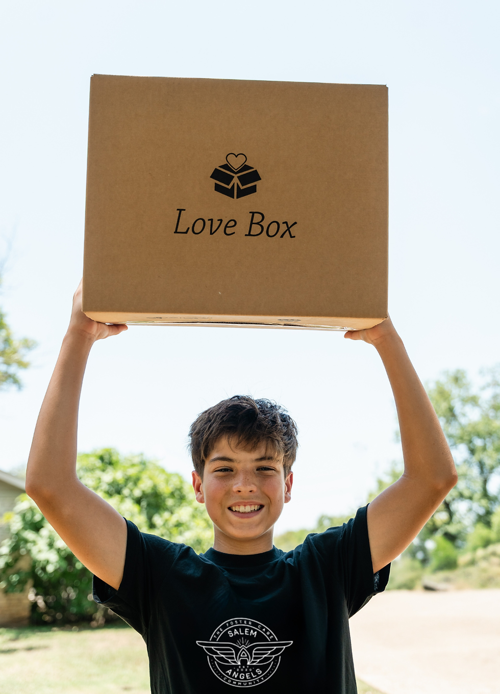 Young man holding a Love Box over his head.