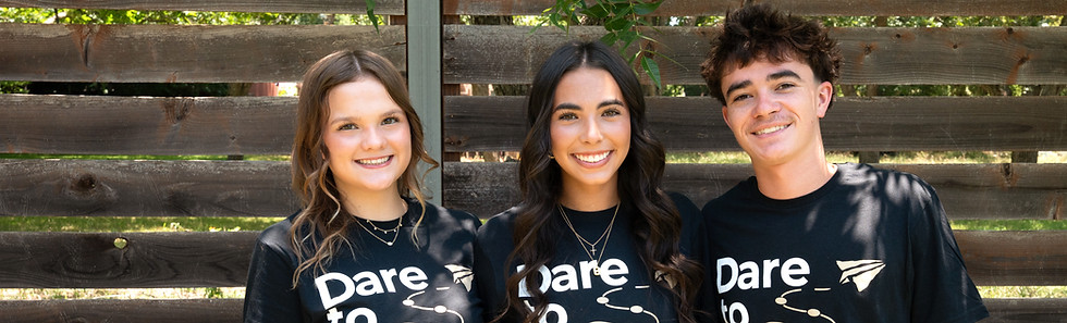 Youth standing shoulder to shoulder wearing Dare to Dream shirts.